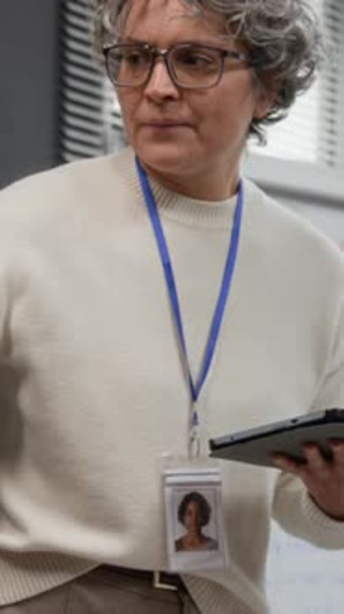 Instructor Holding Digital Tablet while leading Class Vertical
