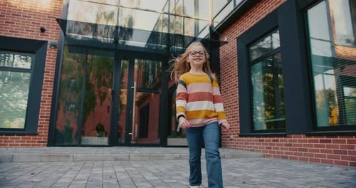 Smiling Caucasian Little Girl Jumping As Walking Home After School Kid Happy About Finished School
