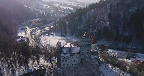 Flyover the Bran Castle in Brasov, Romania on a sunny afternoon during wintertime.