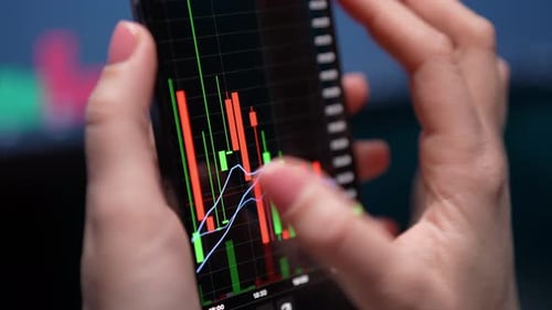 Hands Analyze Stock Market Data on Phone Screen