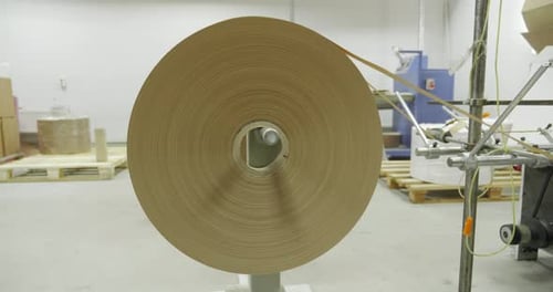 Large Industrial Paper Roll on Machine in Factory Brown Paper Unwinding in Modern Packaging or