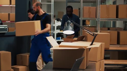 Männlicher Lagerarbeiter, der Vorräte in Paketen organisiert