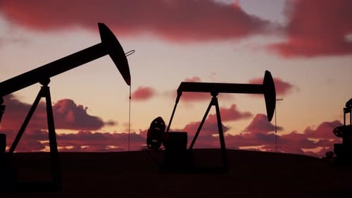 Pumpjacks Working In Oil Field At Sunset With Vibrant Cloud Colors