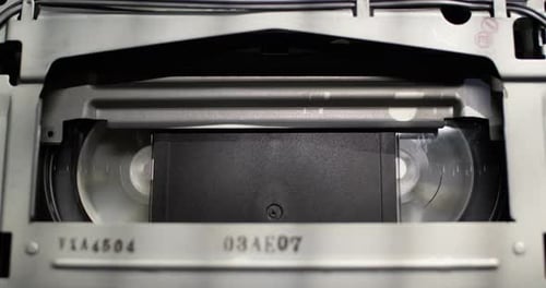 Close up shot of a vintage VHS tape recorder - tape rewind (RWD)