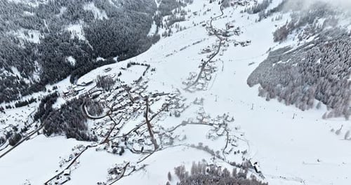Aerial drone view of the Colfosco mountain village covered in snow, in South Tyrol, Dolomites, North