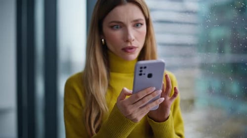 Woman by Rainy Window Upset by Phone