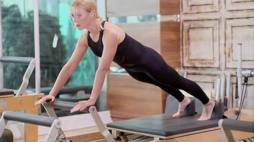 Sportive Blonde Woman Enjoying Pilates Training in Studio After Work