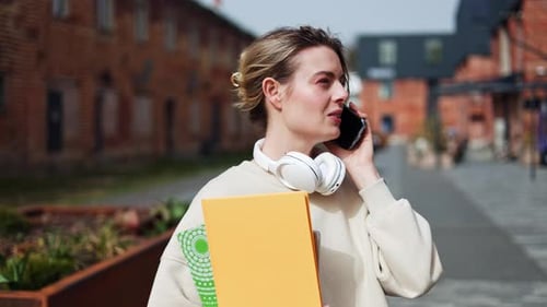 Woman Walks, Talks on Phone Outdoors