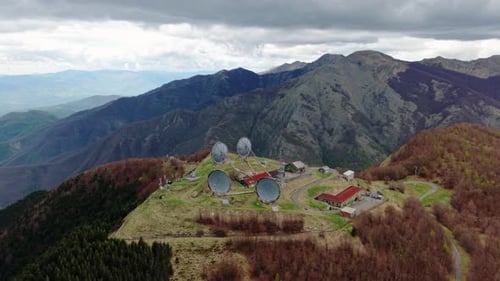 Aerial drone view of an old radar station on a remote mountain surrounded by nature