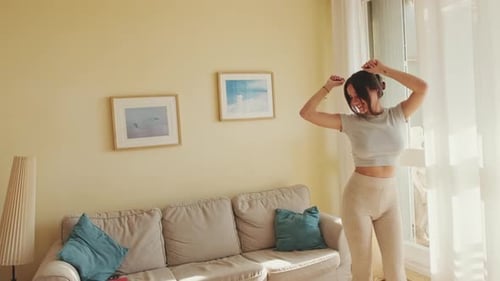 Joven hermosa mujer bailando en casa, celebrando el fin de semana, divirtiéndose. Movimiento hacia adelante