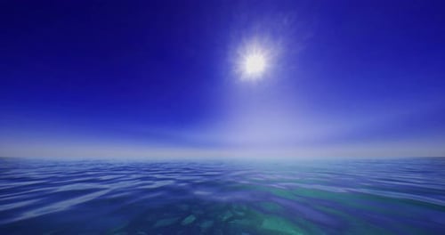 Vue sereine sur l'océan sous un soleil éclatant à midi avec un ciel bleu clair