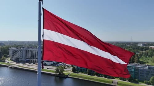 Aerial View of Lithuanian Flag Waving in the Wind with View of Daugava River and Houses on the River