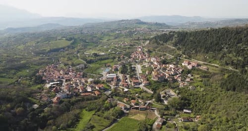 Aerial view of medieval village surrounded by greenery, Italy.