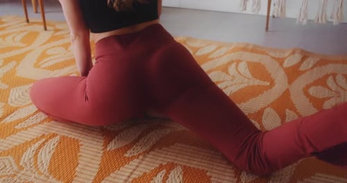 Mujer delgada en forma con un culo redondo perfecto haciendo hendiduras en la alfombra, vista a cámara lenta