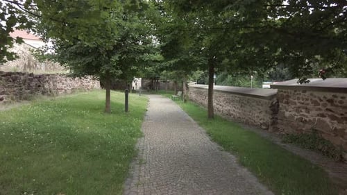 Moody POV shot, flying low over granite path at an empty park on a beautiful day, social distancing