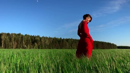 Woman in Red Dress Standing in a Field