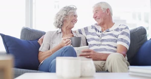 Senior Couple Sharing a Laugh on Couch