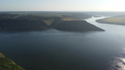 Aerial view of wide Dnister river and distant rocky hills in Bakota area, part of the National park,
