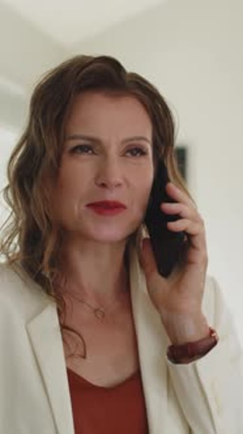 Woman with Brown Hair Talks on Smartphone