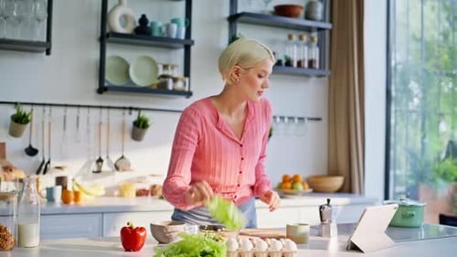 Woman Prepares Salad Following a Recipe on Tablet
