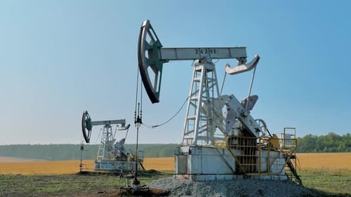 Pumping Rigs Extracting Oil From an Oil Well in Vast Oil Field Oil Industry Equipment
