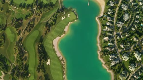 Aerial overhead view of a turquoise lake next to a golf resort with beautiful abstract patterns, san