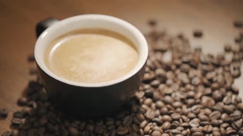 Close Up of Coffee Mug Surrounded by Beans