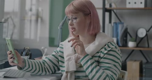 Young Woman Making Online Video Call with Smartphone Discussing Work at Virtual Meeting in Office