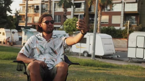 Man Video Calling From Chair Outdoors