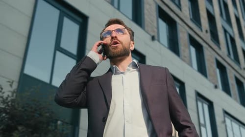 Man Talking on Phone Outside Office Building