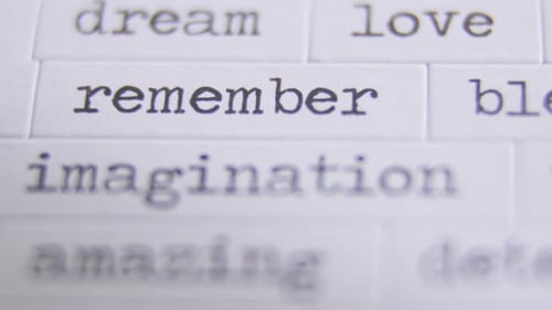 Close up image of multiple words on paper tiles. The word "remember" and "imagination" are centered.