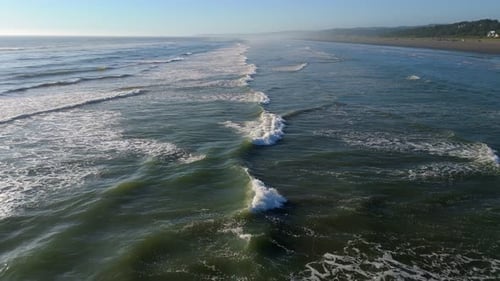 Scenic aerial shot of waves crashing in the ocean and shoreline in the Pacific Ocean. Located in the