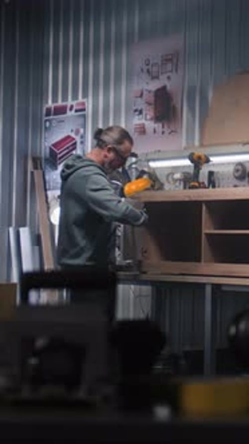 Mature Carpenter Assembles TV Stand Using Screwdriver