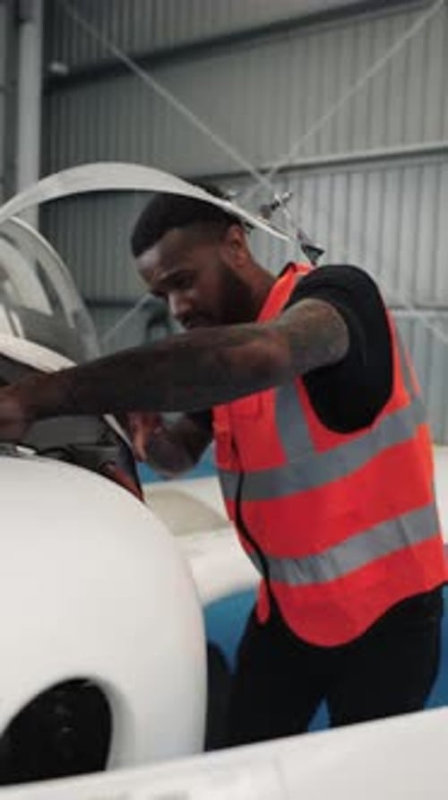 Aircraft Maintenance Engineer Inspecting Plane Engine in Hangar