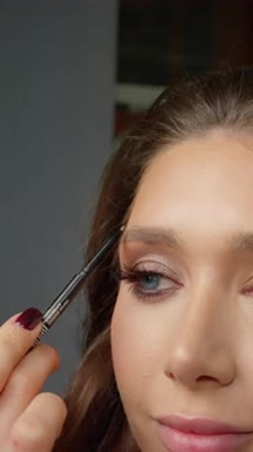 Woman Applying Eyebrow Makeup with Brush Close Up
