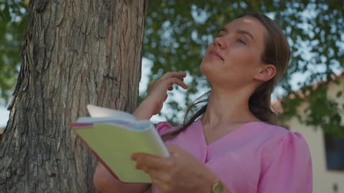 Reflective Female Reader Thoughtful Woman Studies Outdoors Woman Peacefully Reading in Park