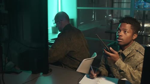 People Working Late at Desks in Office at Night