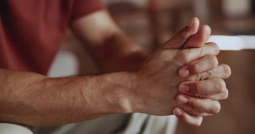 Man Clasped Hands Together Indoors in Close Up