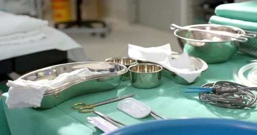 Close up of surgical instruments on table in operating theatre at hospital, slow motion