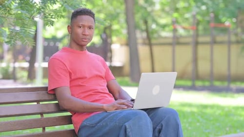 Young Adult Working on Laptop in Park