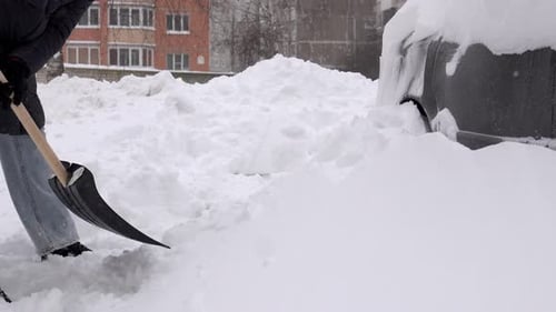Urban morning activity of woman shoveling snow to ensure safety and access
