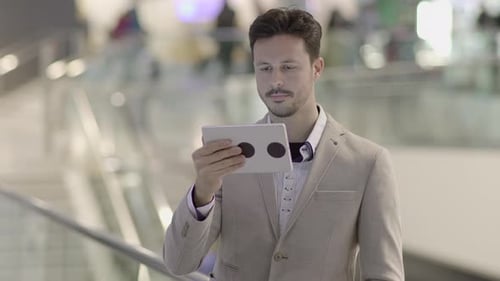 Portrait of Young Successful Man Using Tablet Screen on Business Travel Trip