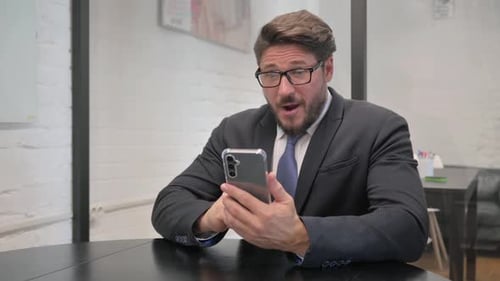 Man Reacting to Good News on Phone in Office