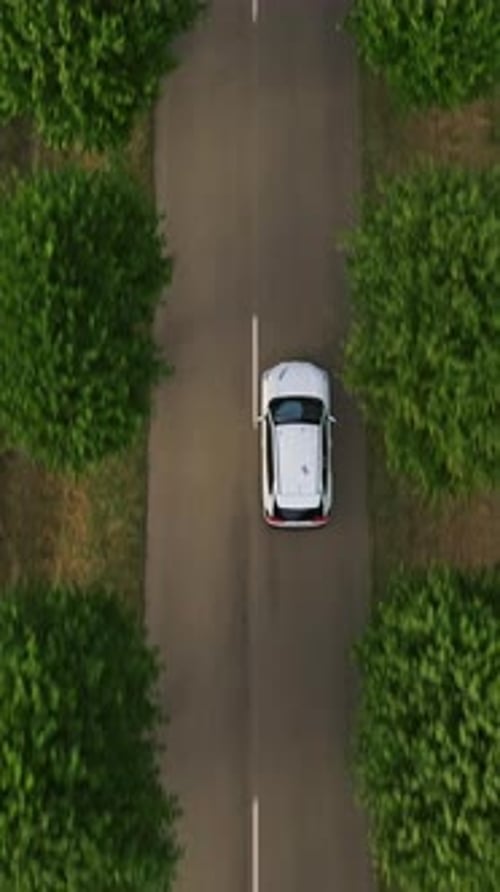 Vertical Video Aerial View of Electrical Car Driving on Country Road at Summer Evening Ecology
