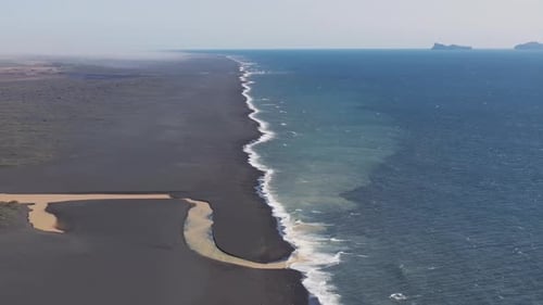 Aerial video over river dune with special colors spilling into ocean, Iceland