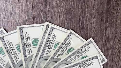 Einhundert-Dollar-Banknoten fallen auf den Tisch