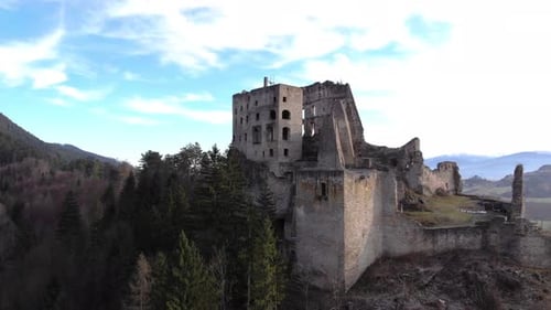 Ruins of an ancient medieval castle seen from below by drone. Aerial 4K footage. Ruins and abandoned