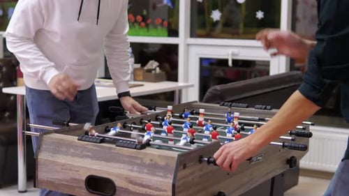 Two Happy and Joyful Friends Together Playing Table Football in the Playing Center