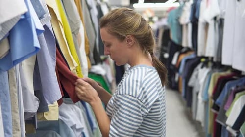 Woman is choosing shirts at a mass market store