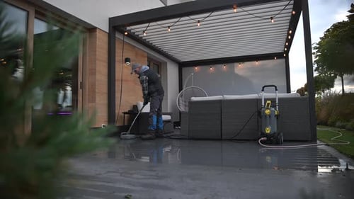 Person Pressure Washer Cleaning Patio Area With Pressure Washer